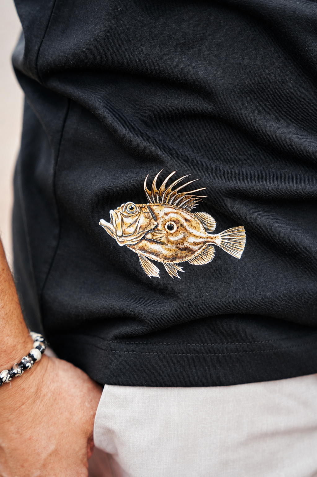 Detalle del estampado inferior de la camiseta Pez Gallo de Fish On Replay.