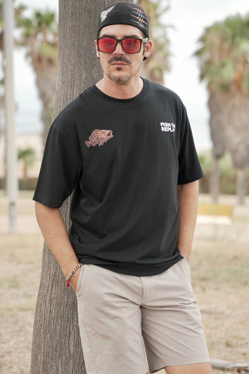 Modelo vistiendo la camiseta Grouper Fish On Replay color negro.