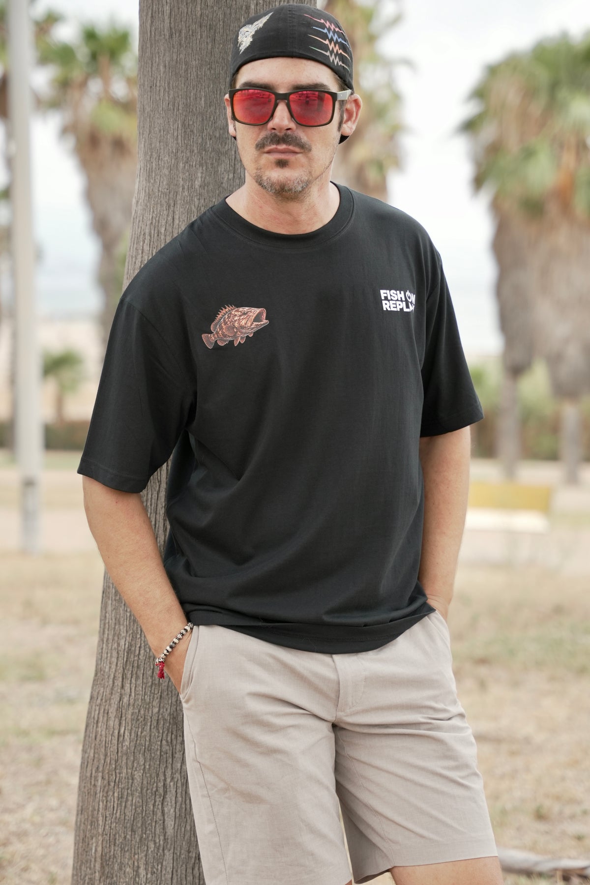 Modelo vistiendo la camiseta Grouper Fish On Replay color negro.