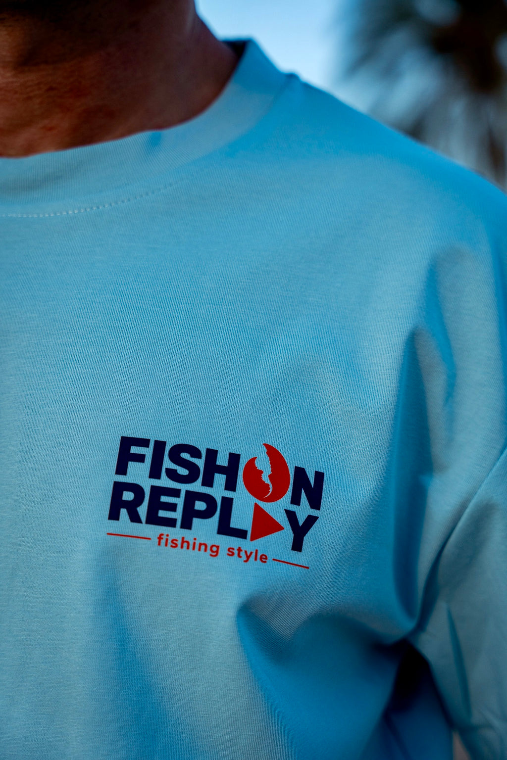Detalle del logotipo Fish On Replay estampado en el pecho de la camiseta Crabbin' Crew.