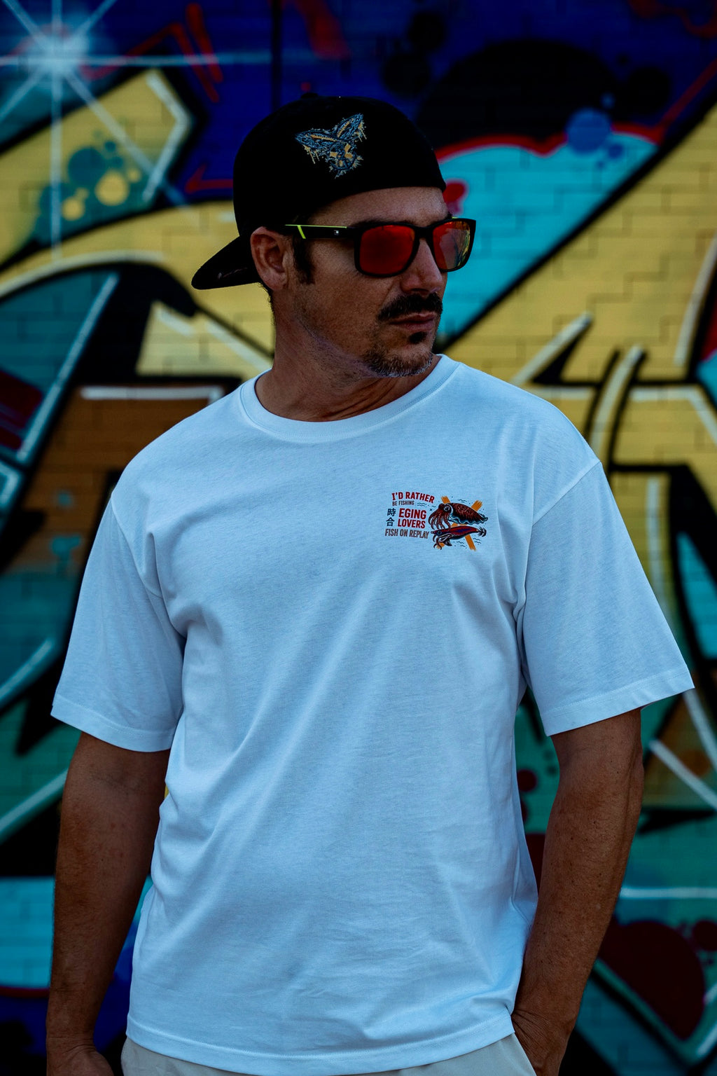 Modelo vistiendo la camiseta Eging Lovers Fish On Replay color blanco.