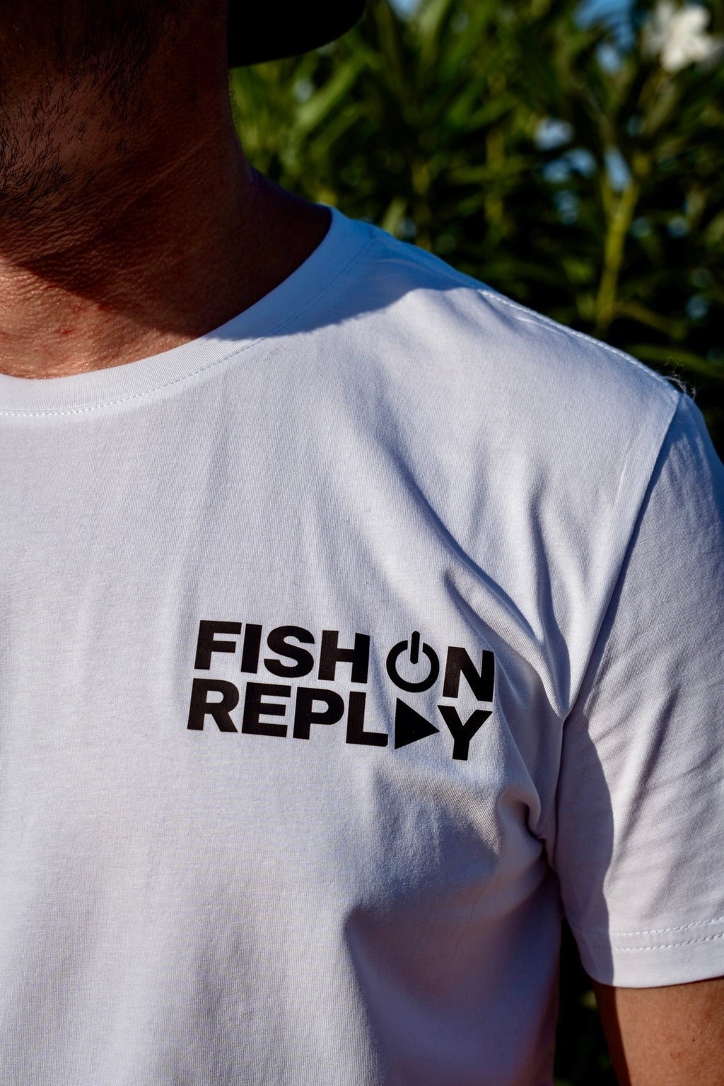 detalle del logo negro de la camiseta blanca hunters de fish on replay 