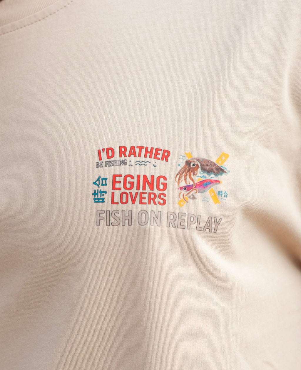 Detalle del logotipo Fish On Replay estampado en el pecho de la camiseta Eging Lovers.